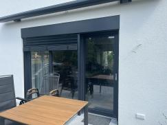 Terrassentür in anthrazit und Holztisch