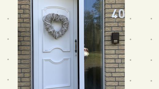 Haustür in weiß mit Glas-Seitenteil und herzförmigem Kranz