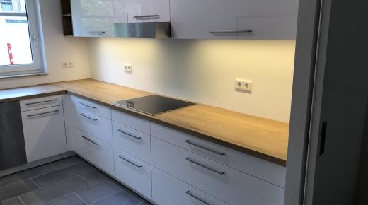 Küche in weiß mit Holzarbeitsplatte und Beleuchtung